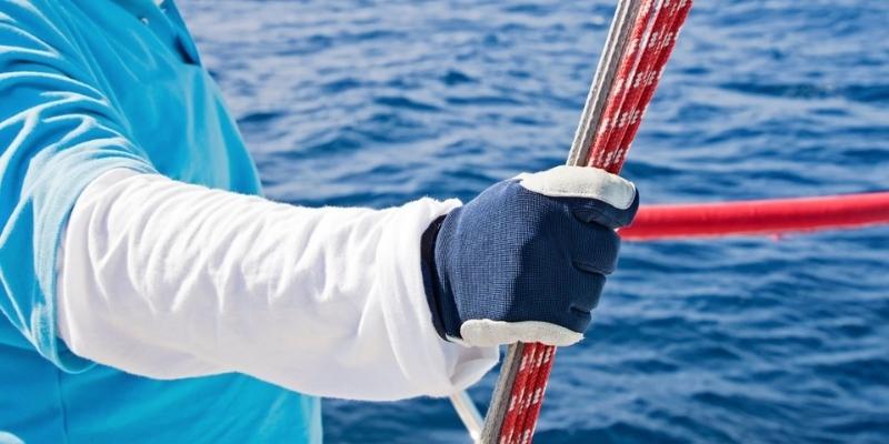 man holding guide sheets on a yacht
