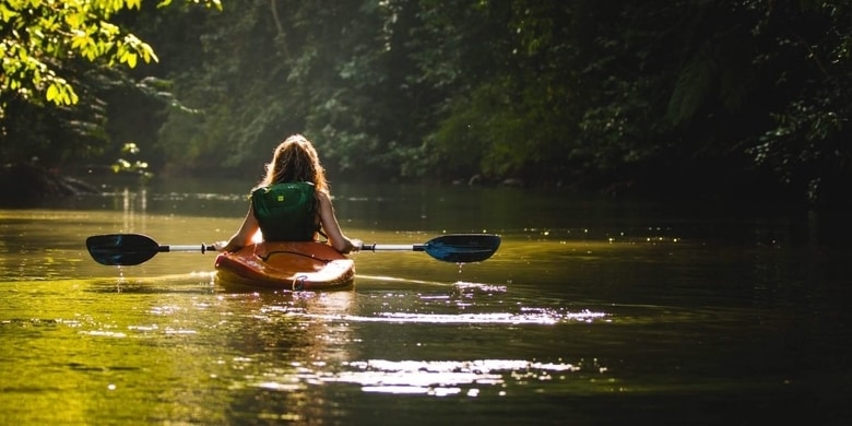 Woman kayaking down a river