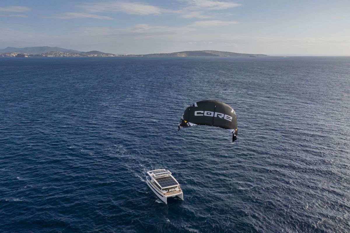 A catamaran motorboat being powered by a kite