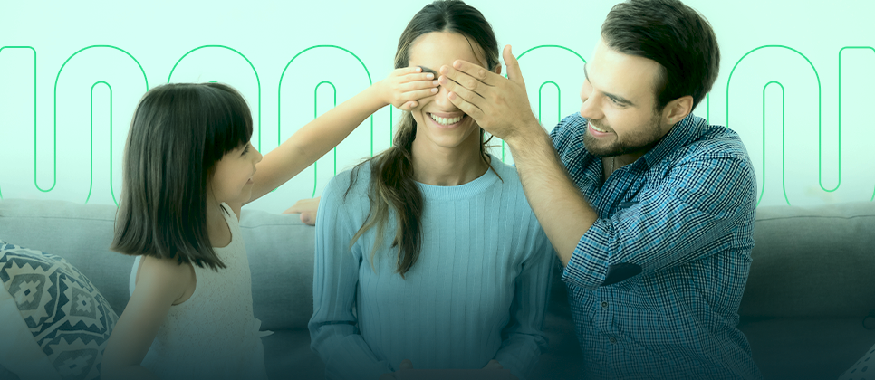 duas pessoas tampando os olhos de outra, enquanto todos sorriem