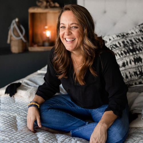 Brandy Alvis Sitting on a bed laughing