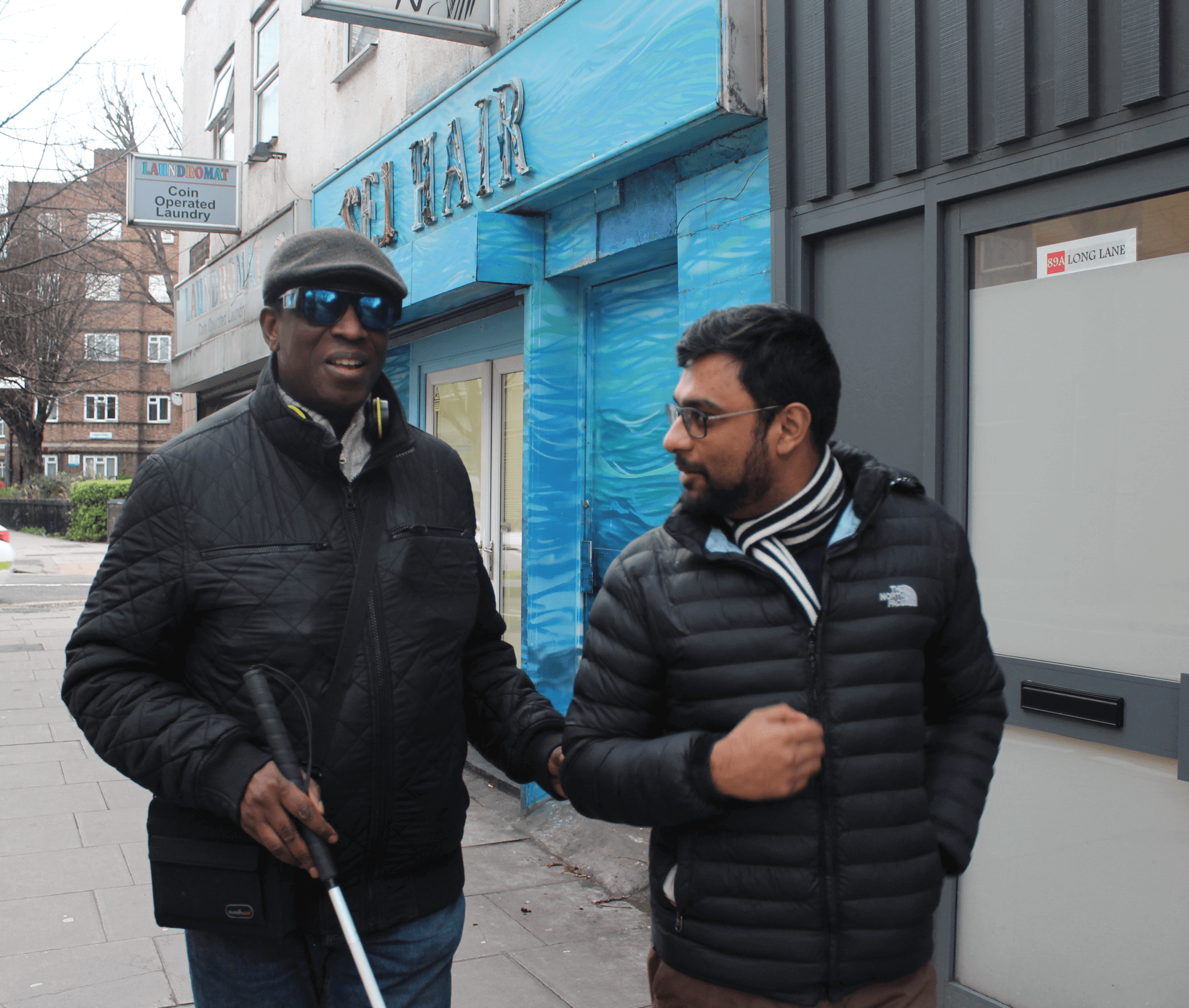 Visually impaired man walking and talking with a volunteer