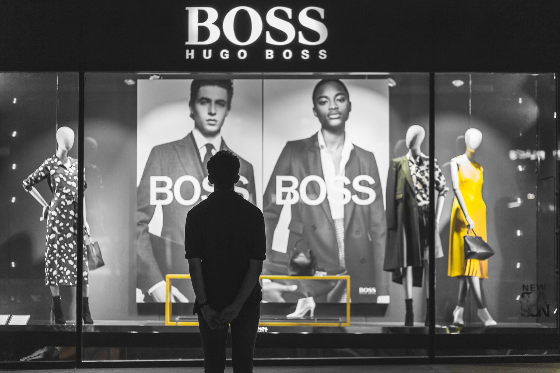 man looking into window of fashion shop