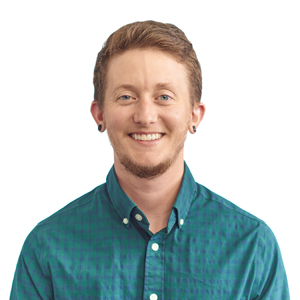 A photo of Riley, a person with white skin, smiling, short brown hair, in a teal shirt