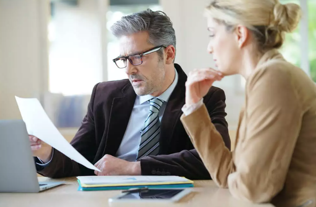 Attorneyreading documents with a client. 