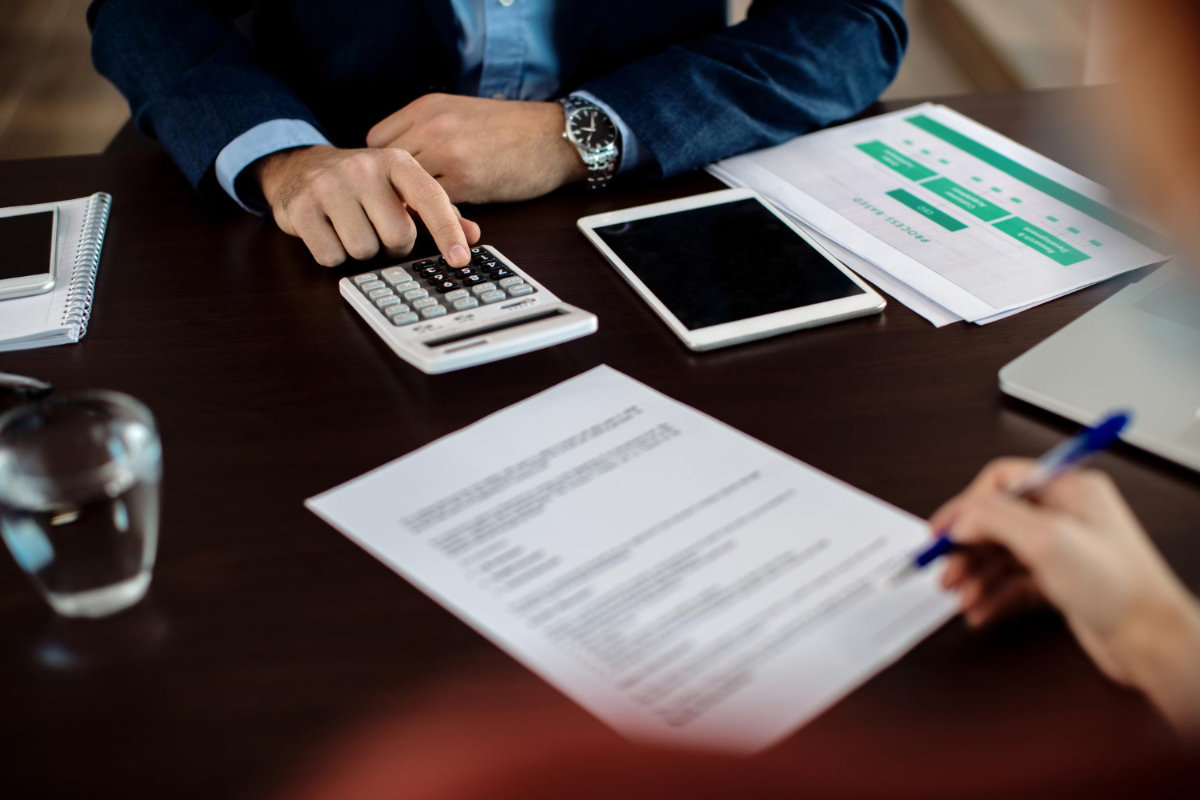 Meeting of two people calculating numbers and filling a form.