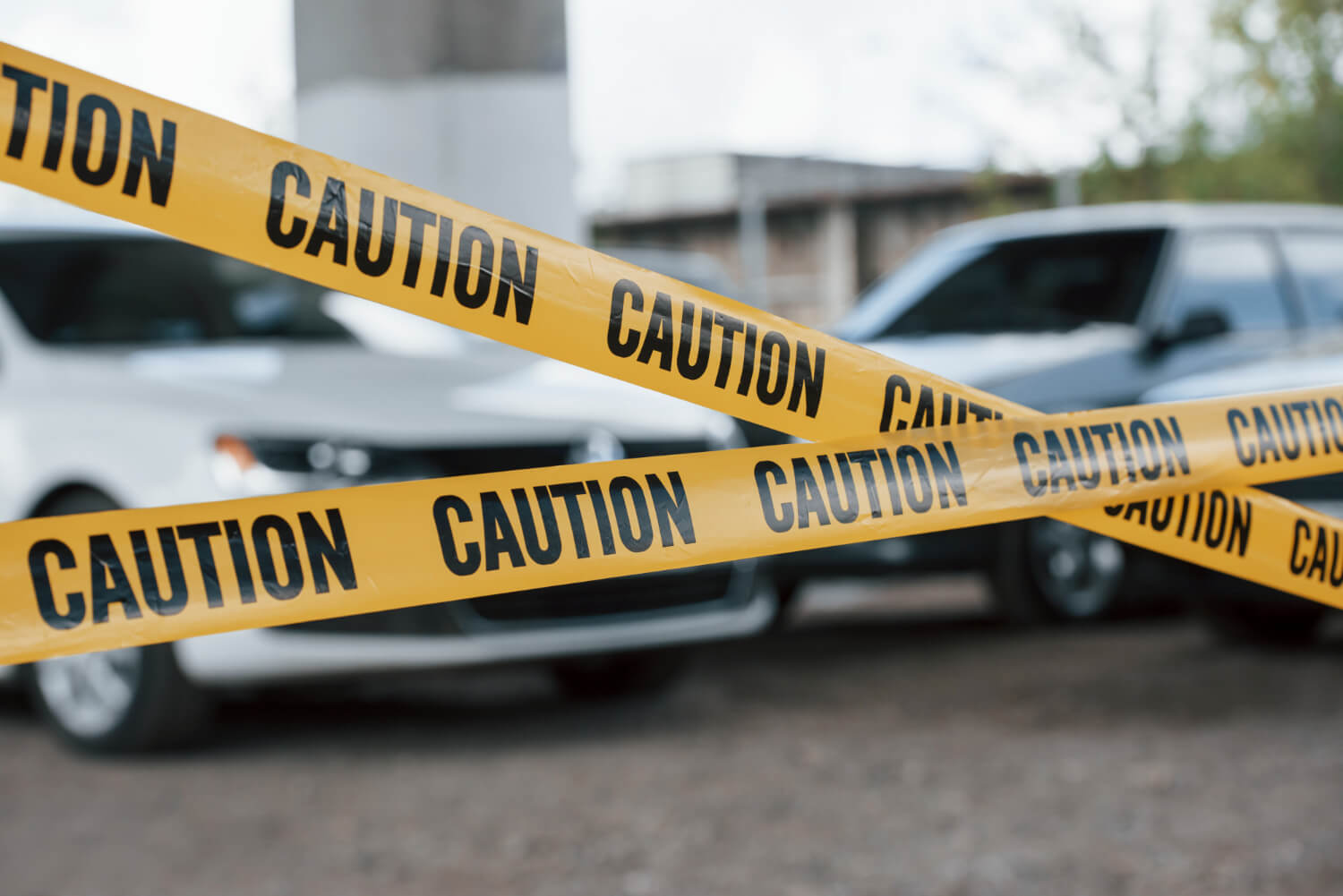 Black and white vehicles. yellow caution tape near the car parking lot at daytime.