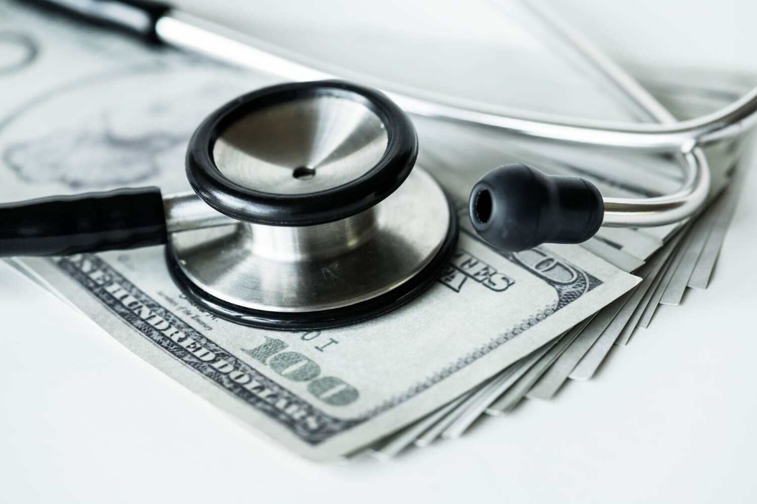 Foto de cerca de dinero en efectivo y un estetoscopio de la salud y el gasto