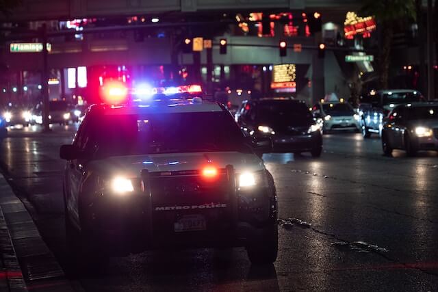 Coche de policía en el arcén con luces intermitentes. 