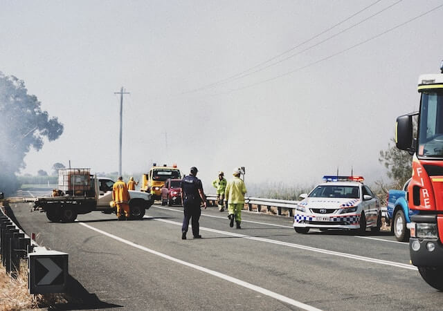 Vehículos de emergencia estacionados en la autopista con luces intermitentes. 