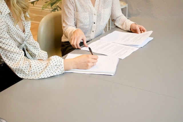 2 mujeres revisando varios documentos 