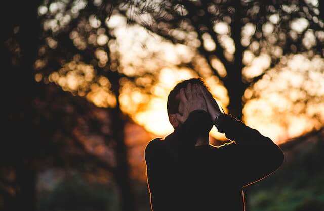 Hombre llevándose las manos a la cara con estrés 