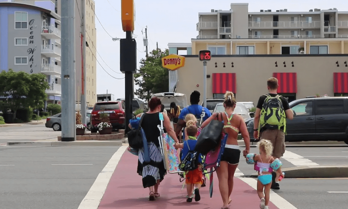 Familia de vacaciones en una acera peatonal