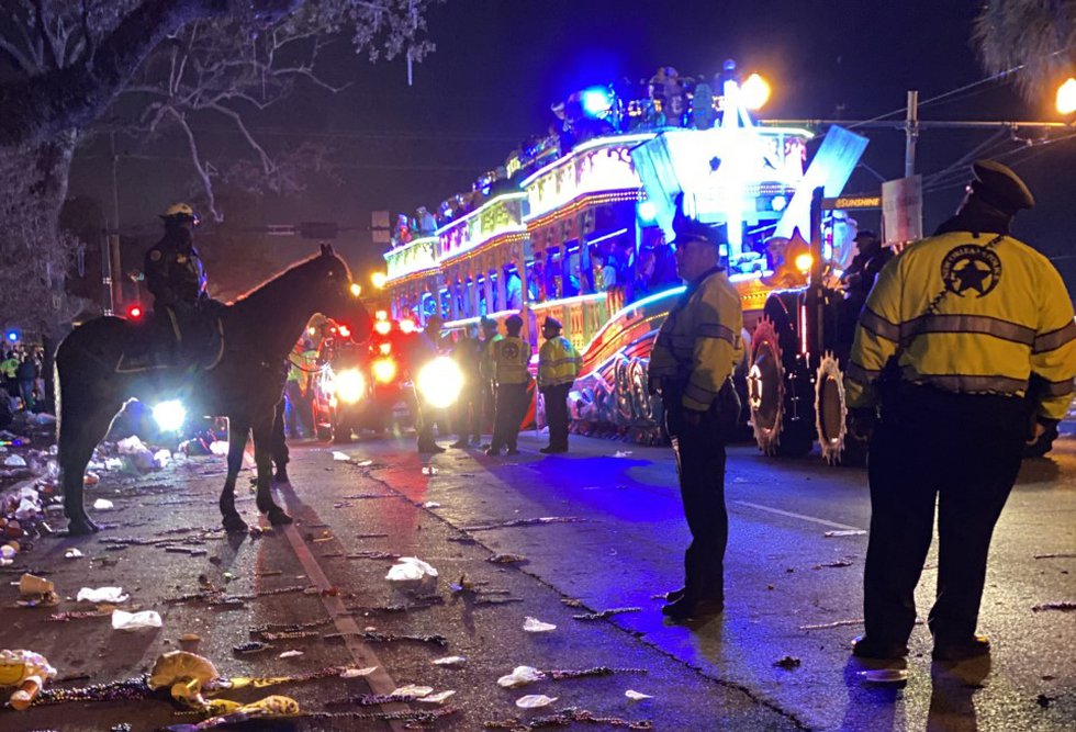 Desfile nocturno con agentes de policía y basura en la carretera.