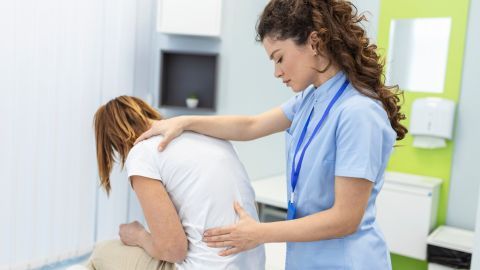 fisioterapeuta haciendo el tratamiento de curación womans dolor de espalda paciente tratamiento