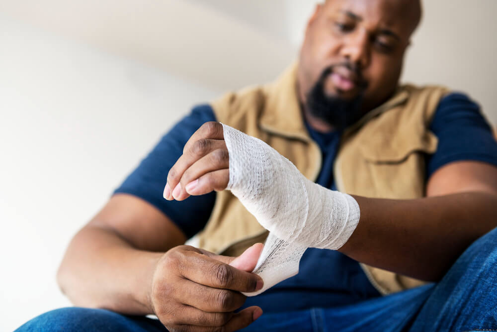 person bandaging himself