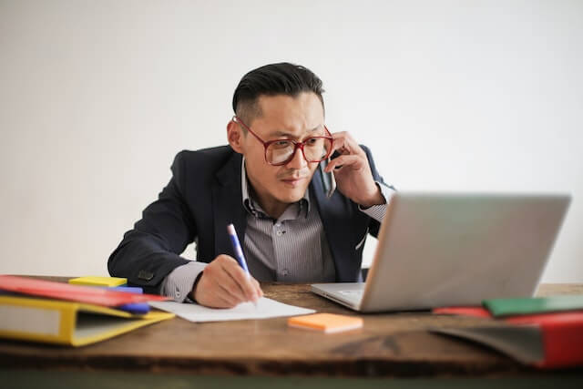 a man investigating cases at his desktop writing down the evidence