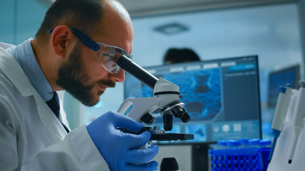 lab-technician examining samples liquid using microscope equipped laboratory