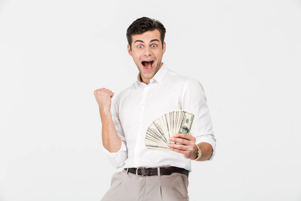 Hombre alegre con un fajo de billetes en la mano 