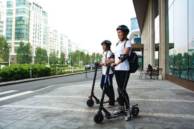two women riding their scooter ready to go