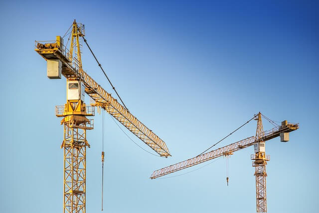 Imagen de dos grandes grúas de construcción. 