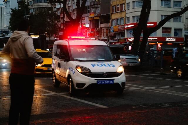 Coche de policía pasando con las sirenas encendidas. 