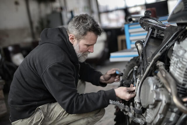 Hombre reparando motocicleta 