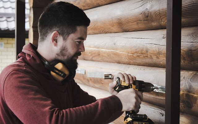 Hombre reparando una pared de madera. 