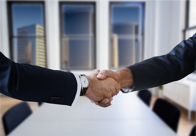 Lawyer shaking hands with insurance company representative. 