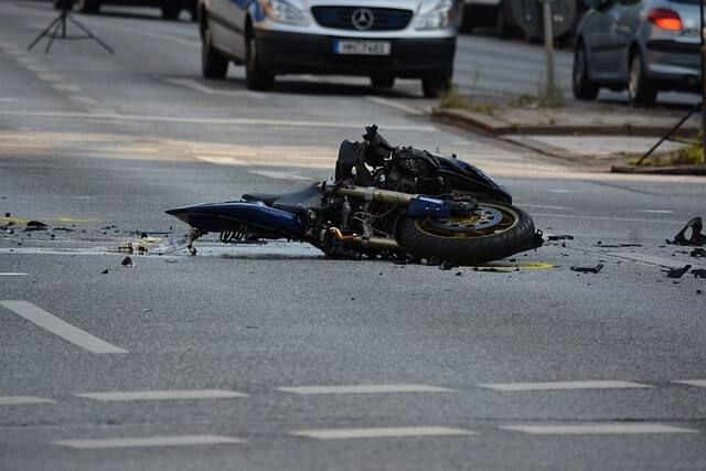 Motocicleta tendida en el asfalto tras sufrir un accidente. 
