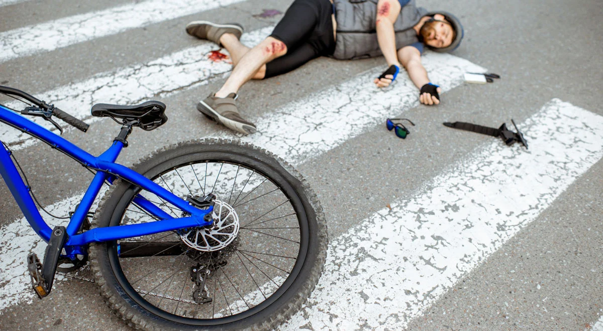 Man and bicycle laying on the road after suffering an accident while riding