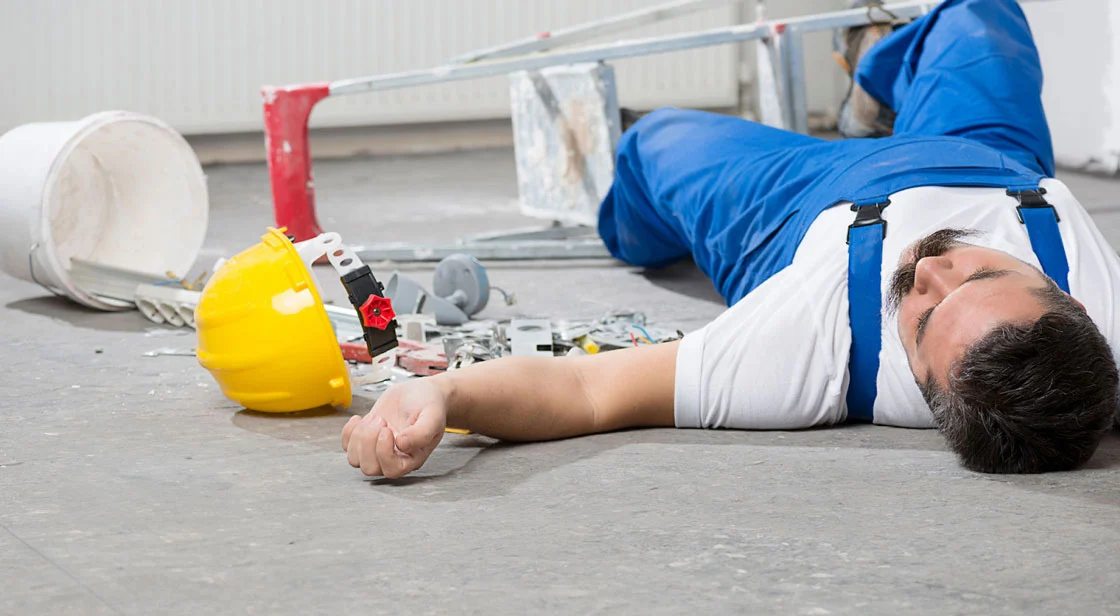 Man laying on the floor after falling from ladder while working in construction.
