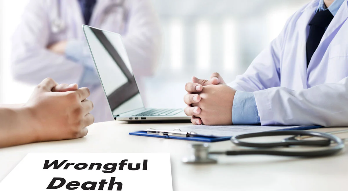 Doctor and patient close up sitting in a desk with a wrongful death paper between them. 