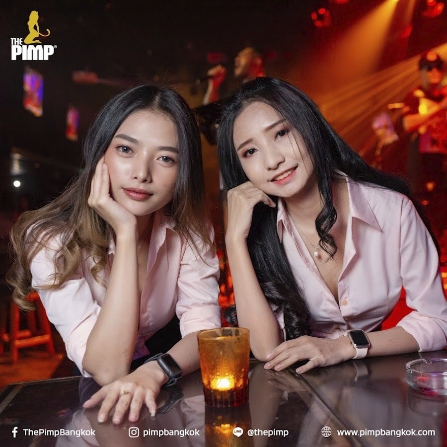 two young cute Thai girls from The PIMP gentlemen club looking straight into the camera