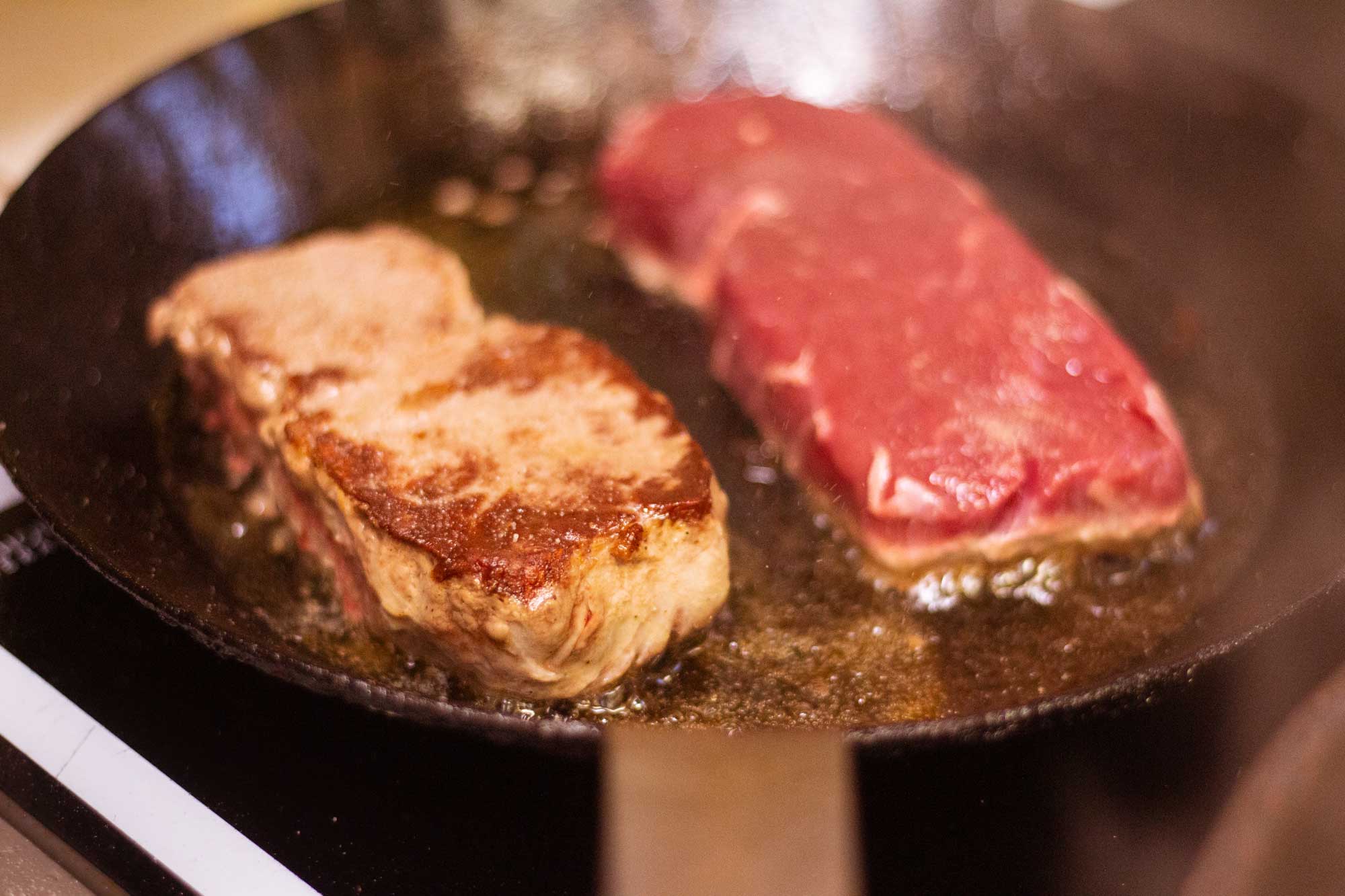 Rumpsteak während der Zubereitung in der Pfanne