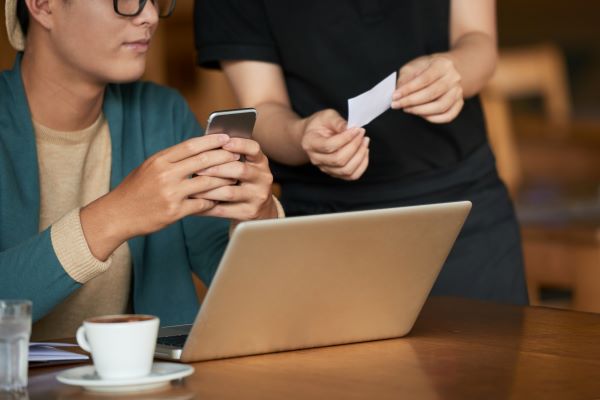 Woman paying for her coffee in a coffee shop