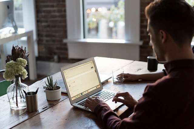 Young man working at a table on a laptop