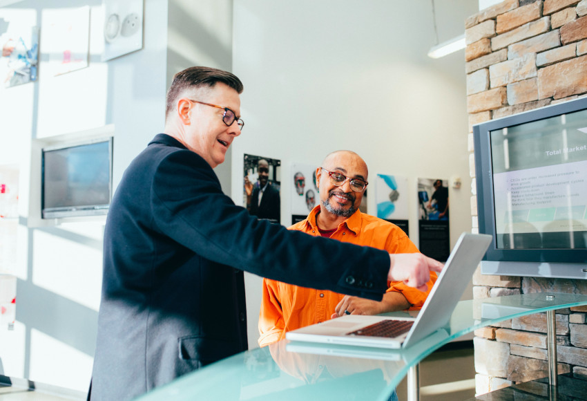 Two men looking at a laptop