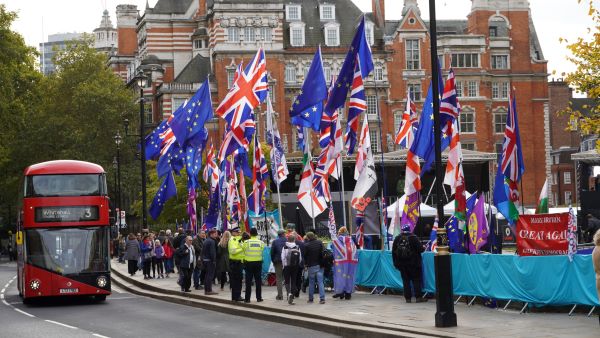 London, red bus passing by Brexit protesters