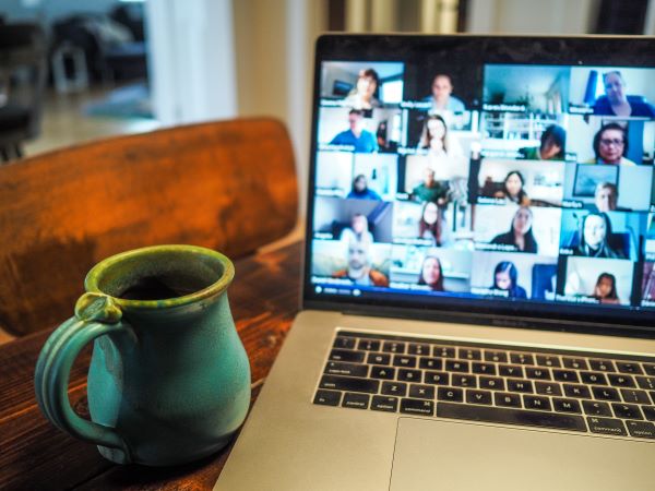 Coffee cup beside laptop with Zoom meeting