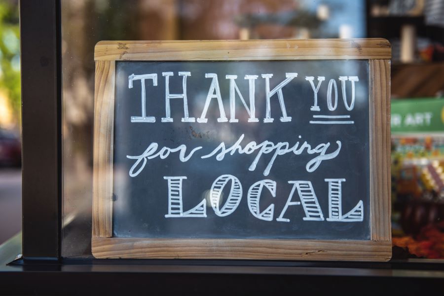 Chalkboard in cafe saying 'thank you for shopping local'