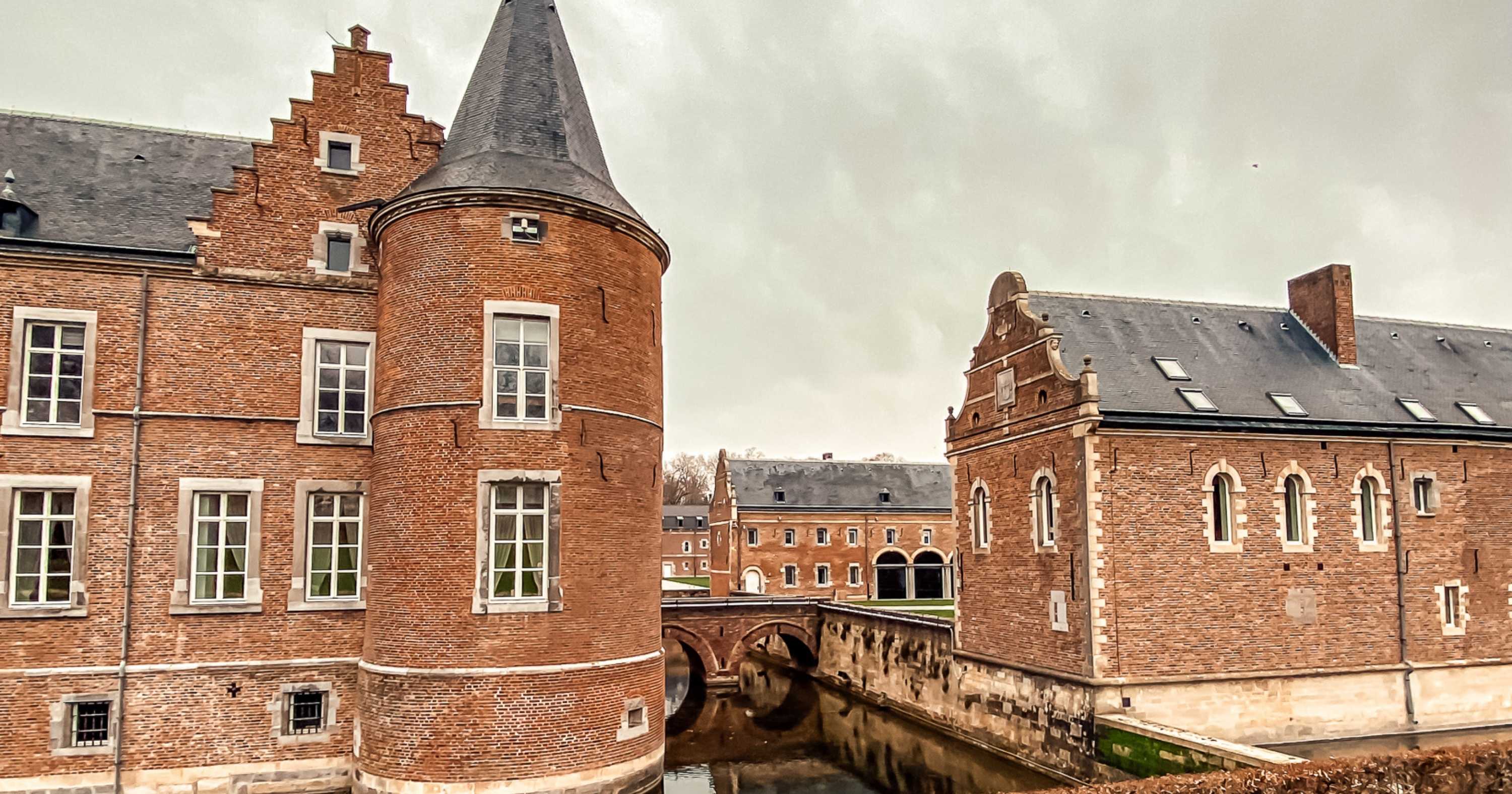 The exterior of a grand, red-bricked castle building at Alden Biesen, Belgium