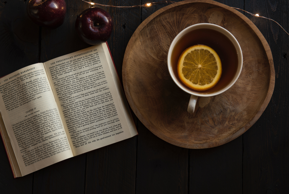 Visuel relaxant : un livre ouvert, une tisane au citron et quelques pommes.