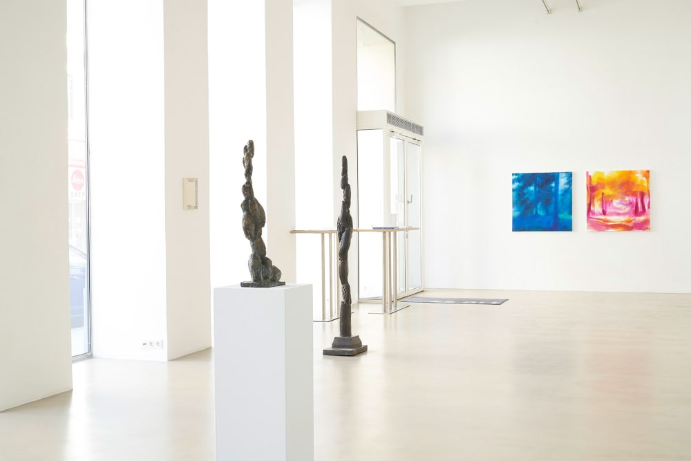 ZS Art Gallery shows the gallery space with high white walls and high windows showing paintings and sculptures
