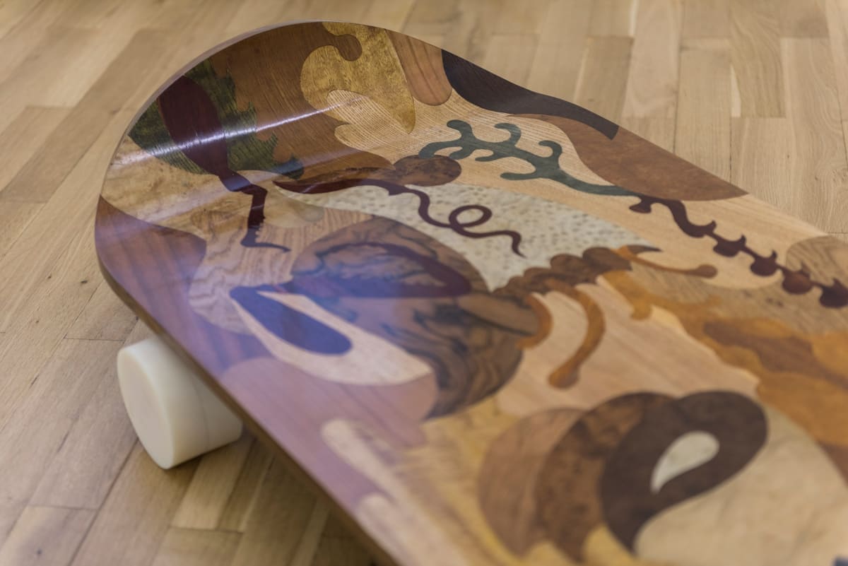 Image shows close up of a scateboard made up of different wood colorings showing natural forms
