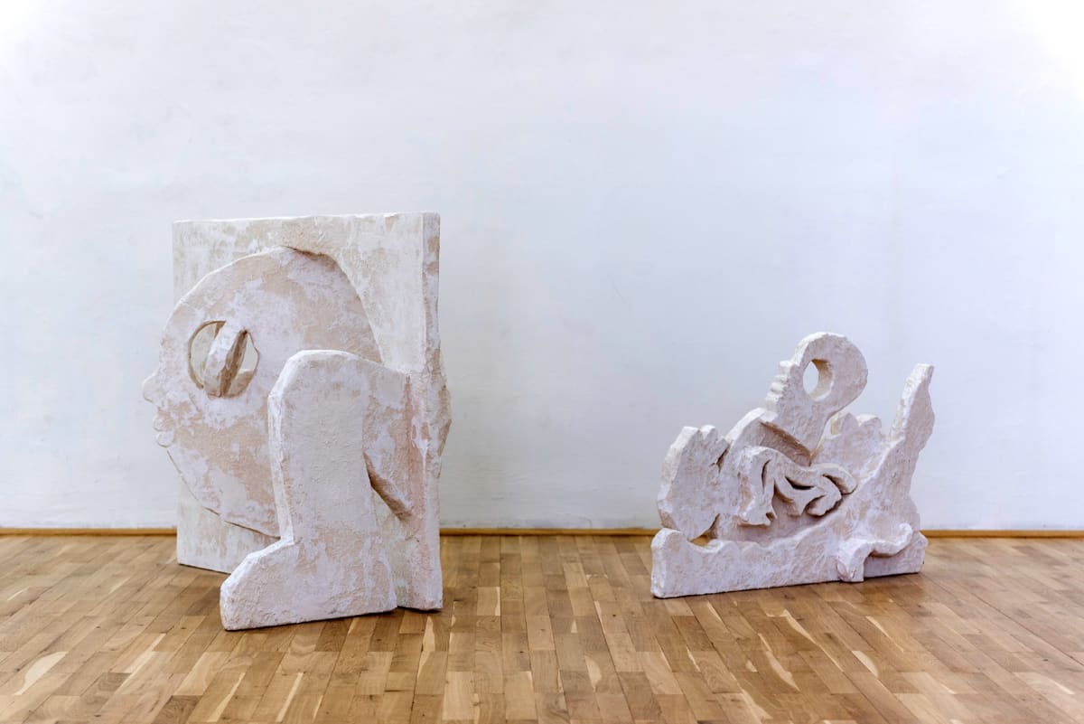 Image shows tow white stoned sculptures on the floor