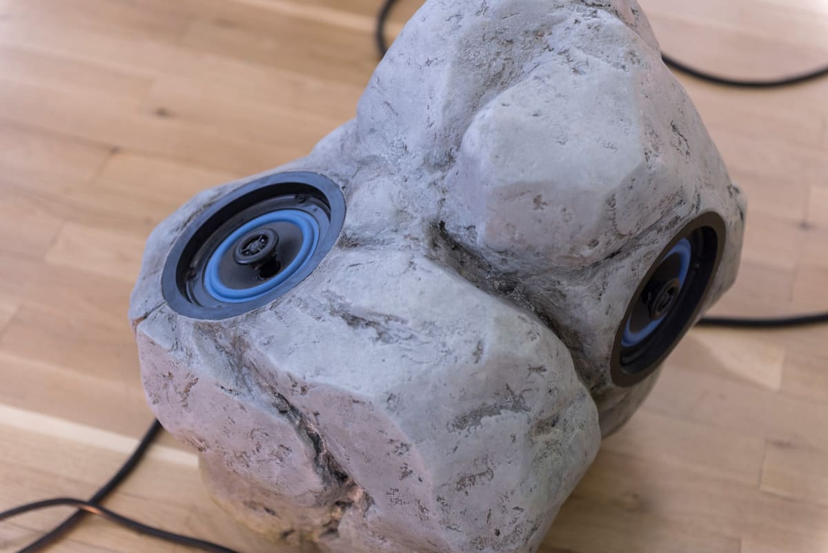 Close up of an installation lying on the floor and cables coming out and what seems like 2 speakers