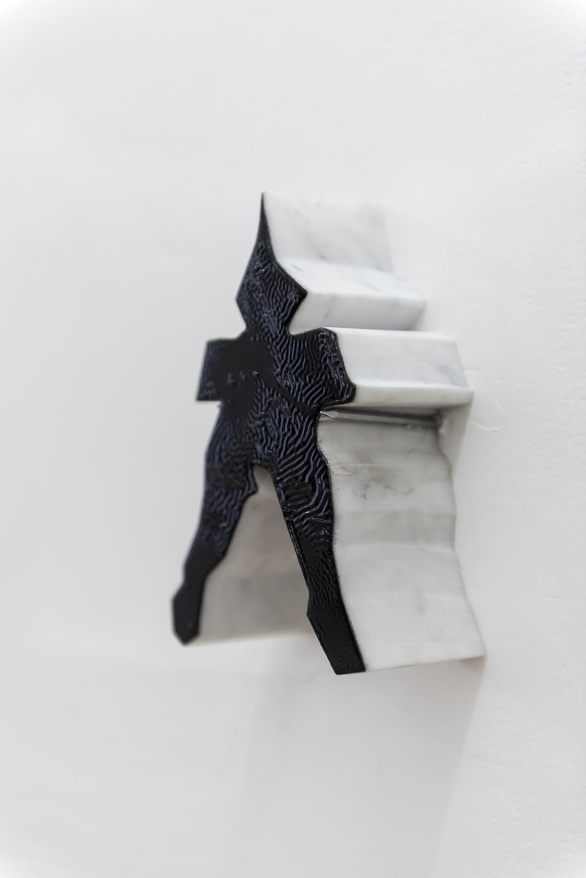 the image show a figure that has been sawed out of another artwork hanging on the wall painted in black in the front