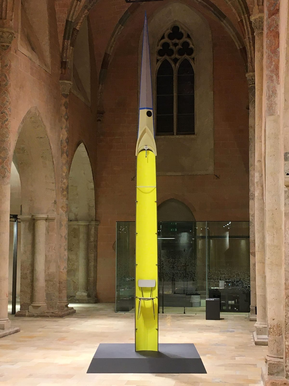 roman pfeffer, iimage shows a life size yellow rowing boat standing like a pilar upwards with a chair attached.