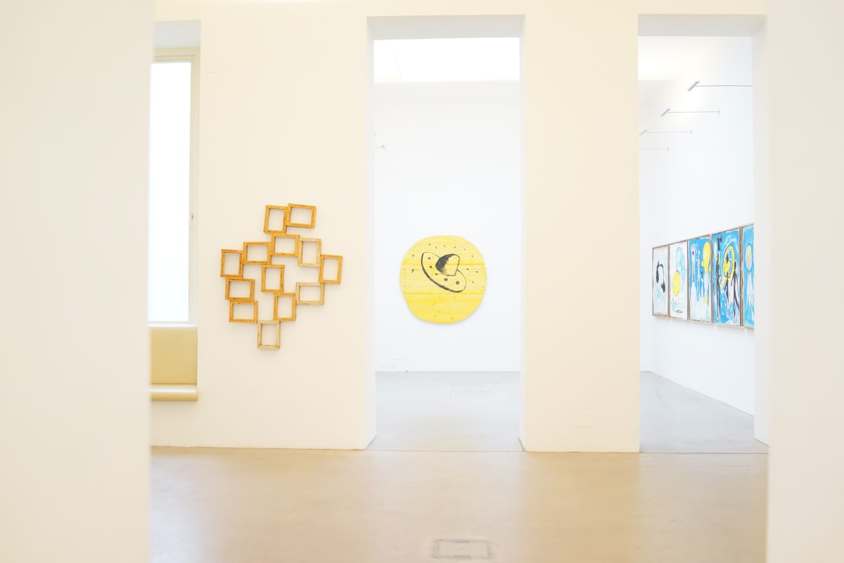 ernst koslitsch exhibition we have to move the island shows the gallery raum mit licht with 2 scultures in yellow wood, one with a large sombrero looking ufo and three paintings in the very back